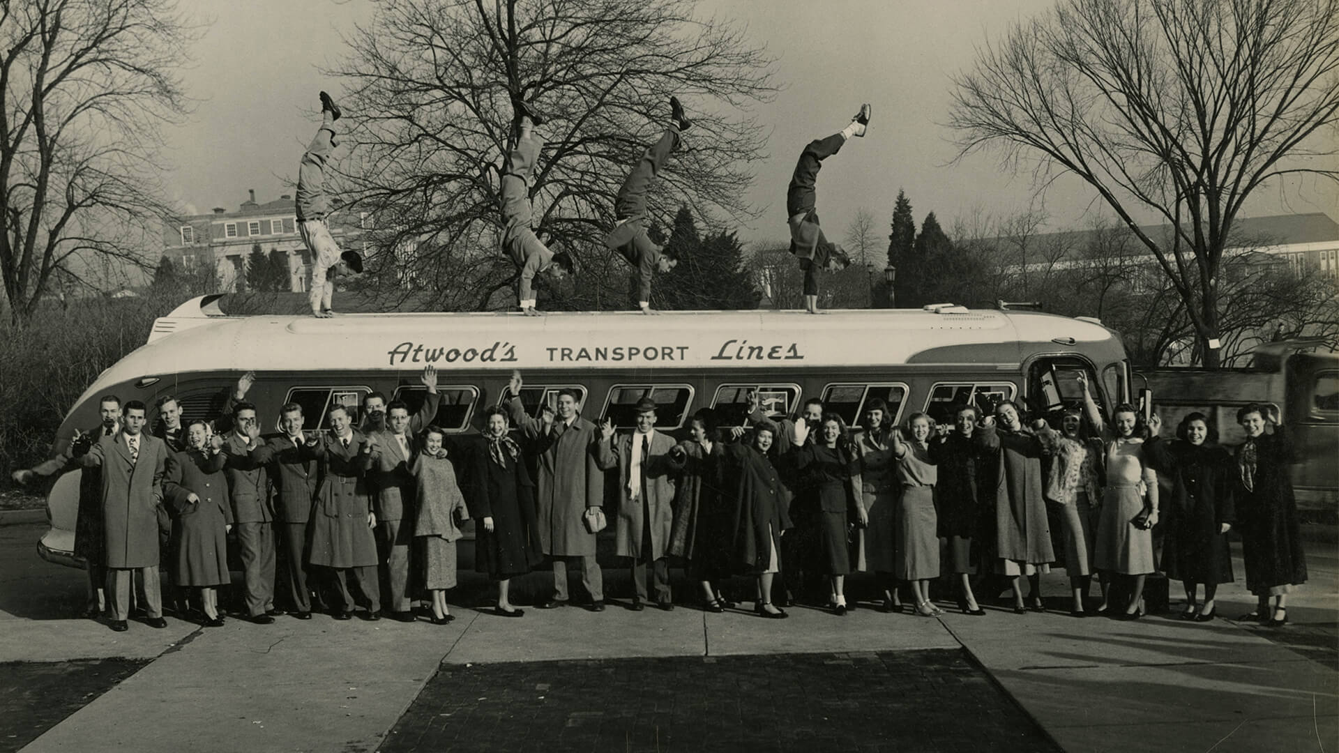 Gymkana members do handstands on top of a bus