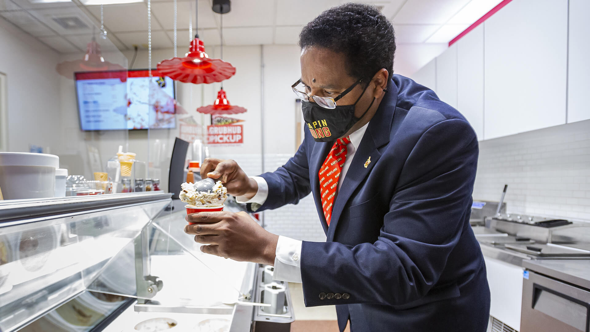 President Pines scoops ice cream into cup