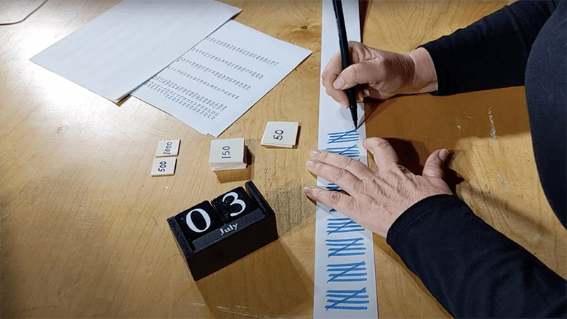 Close-up of Elizabeth Katt making tally marks