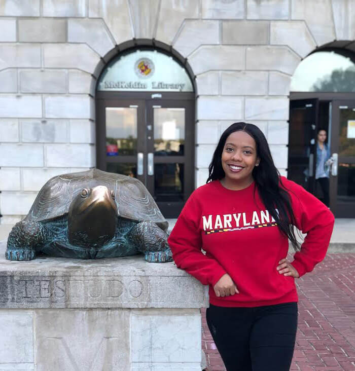 Saba Tshibaka posing next to Testudo statue