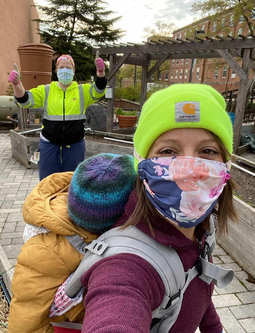 Two gardeners wear face masks