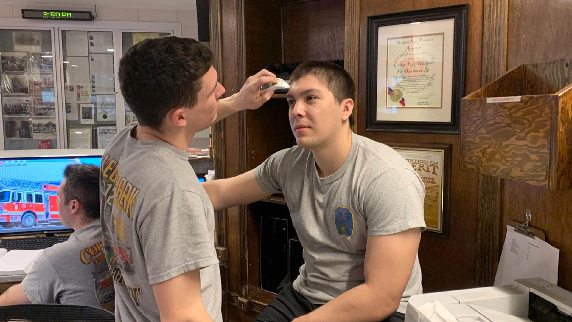 Student volunteers take each other's temperature