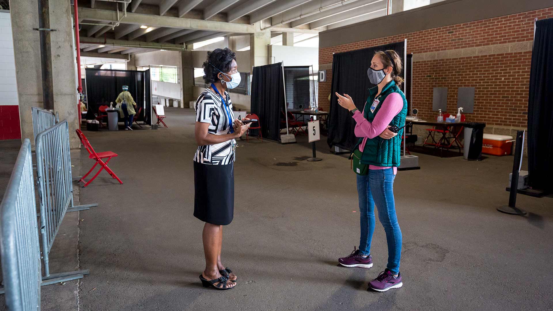 Dr. Bodison speaks with Heather at the Maryland Stadium testing. Both wear masks.