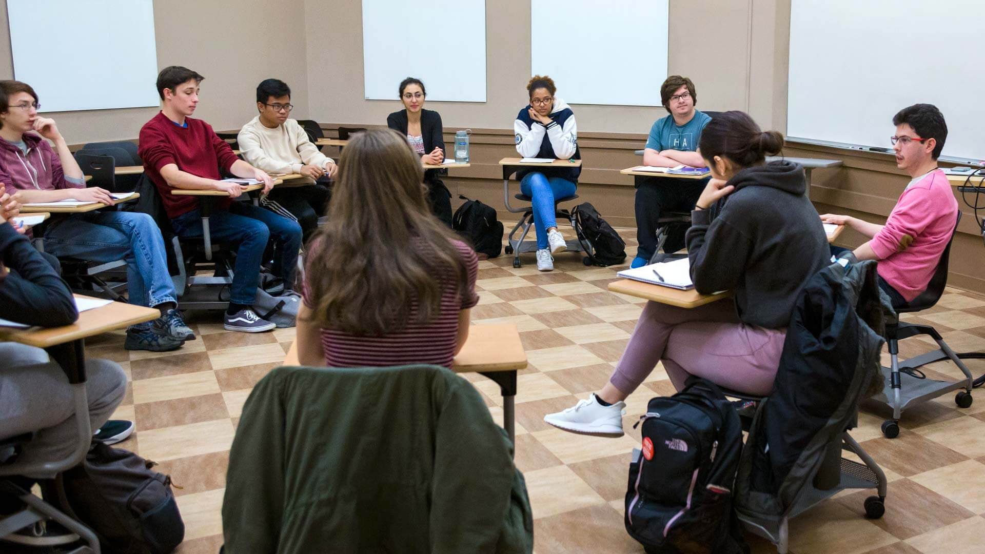 Students sit in circle of desks in Eye2Eye TERP Classroom