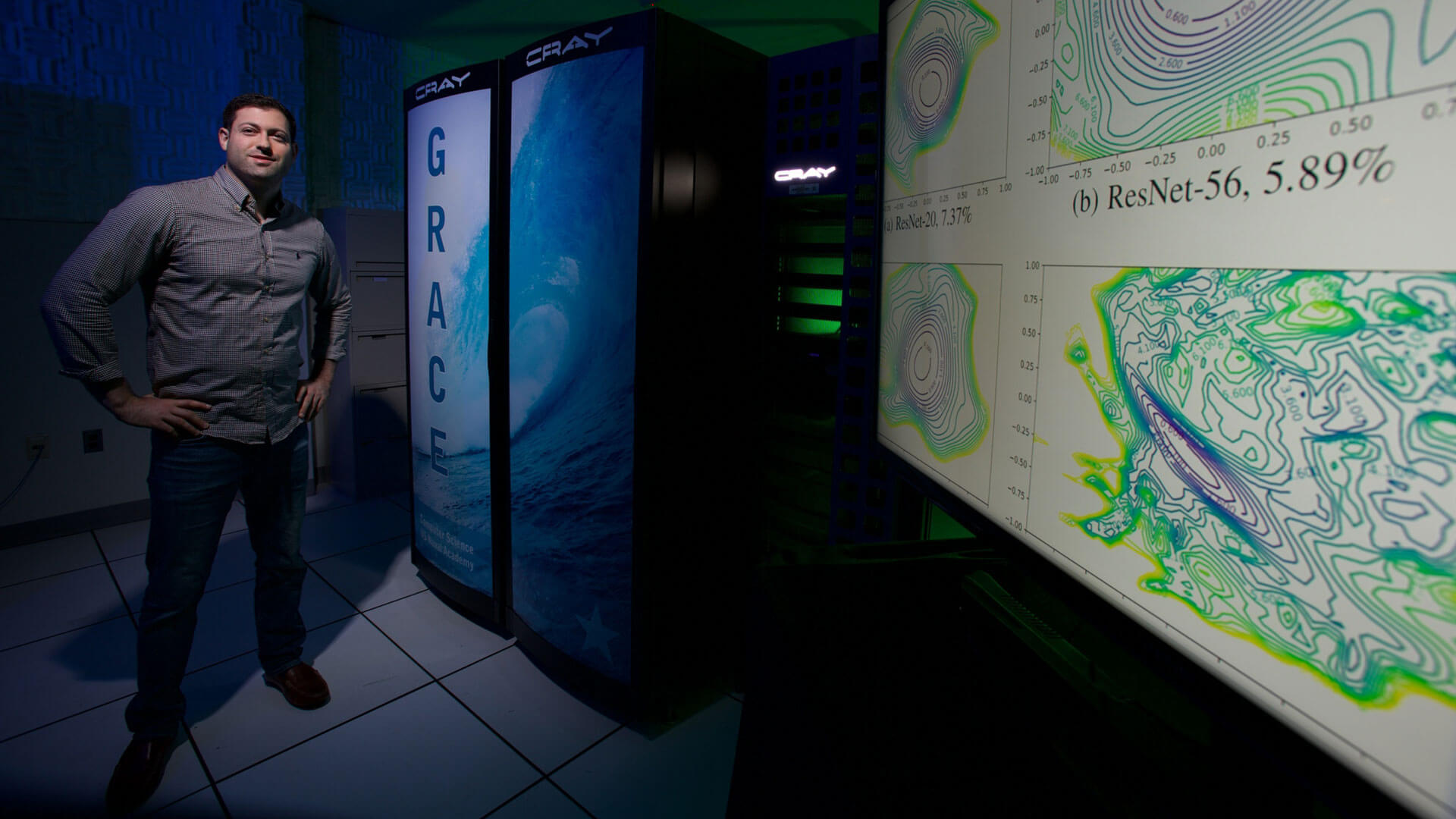 Man posing next to charts/graphs